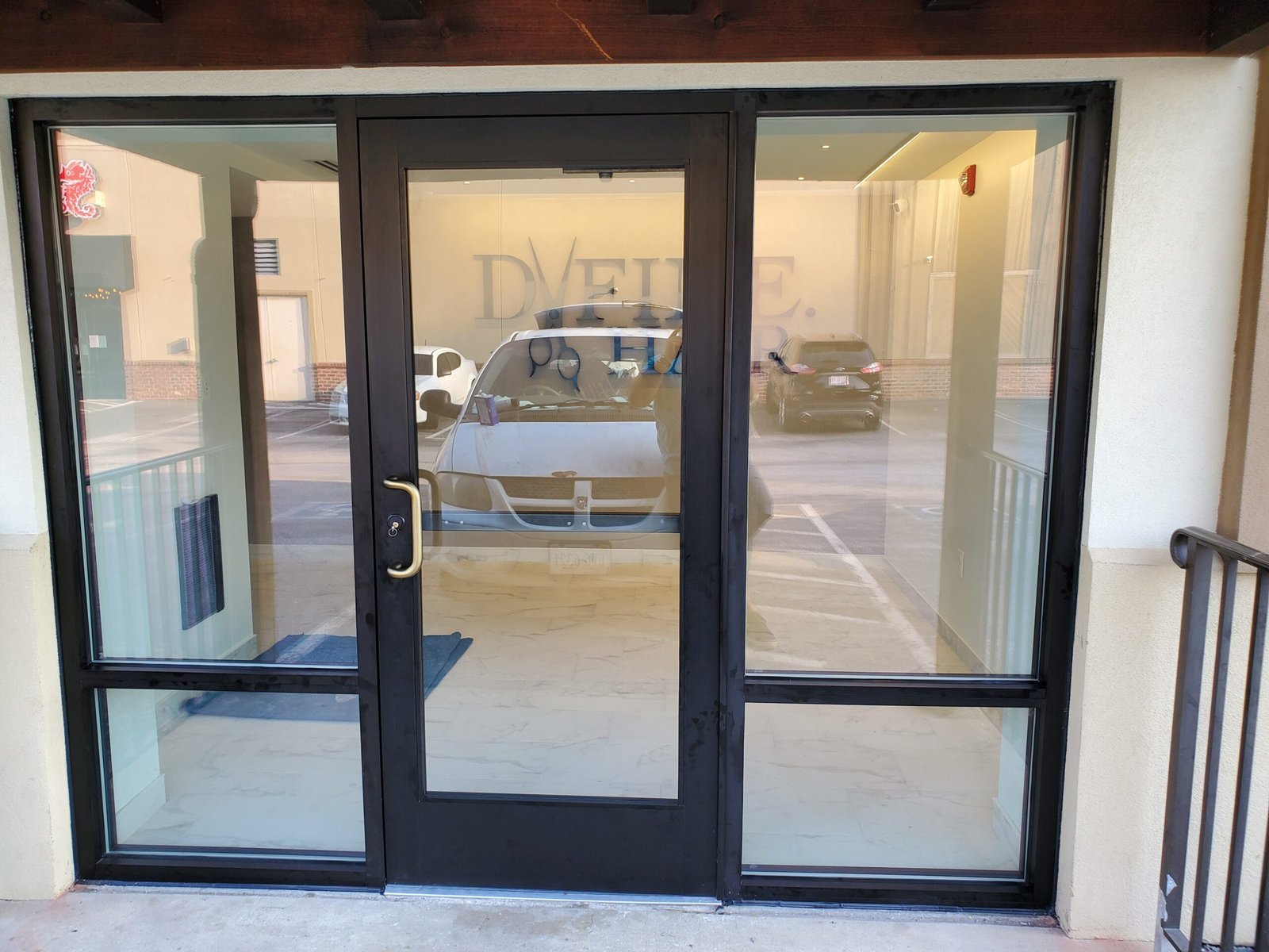 Black aluminum storefront entrance with glass door and sidelites