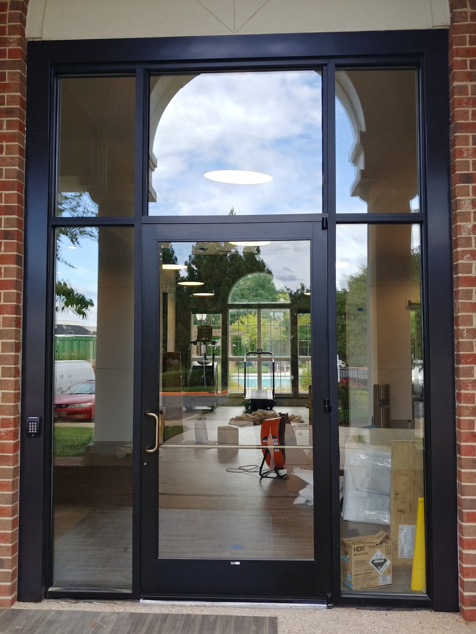 Dark bronze aluminum storefront entrance with glass door, sidelites and transom